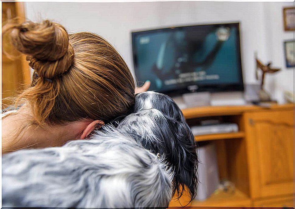 Owner with her dog watching TV